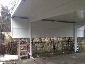 This car port has a partial wall to shield the car from wind and elements.