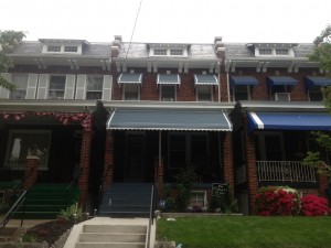 Gray aluminum awning and window hoods in a rowhouse